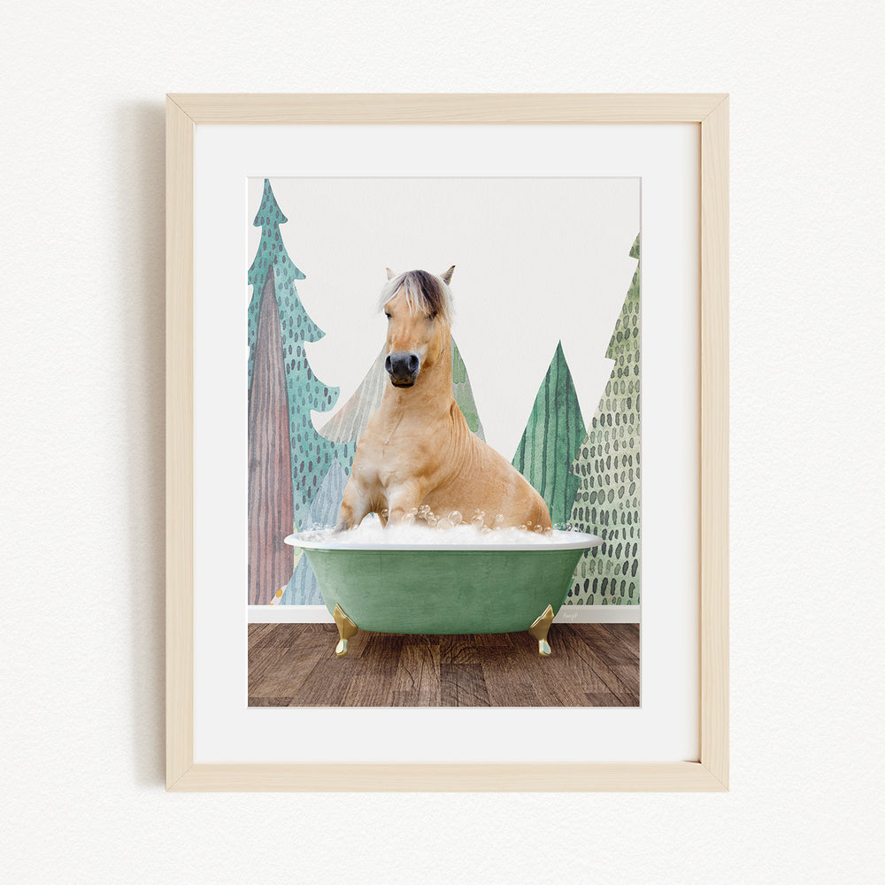 A light brown horse is sitting in a green bathtub, surrounded by a forest-themed background with green trees and a white sky.