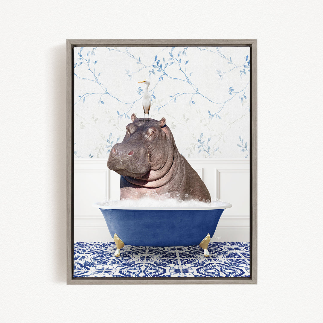 A framed image depicting a hippopotamus sitting in a blue bathtub, with a bird perched on its head.