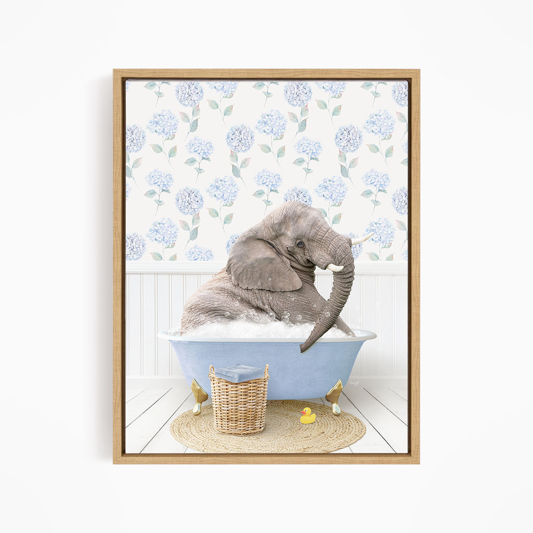 A gray elephant is sitting in a blue bathtub filled with water, surrounded by a wicker basket and rubber duckies.