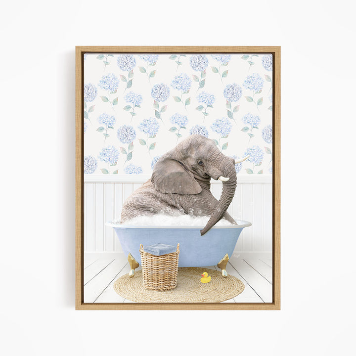 A gray elephant is sitting in a blue bathtub filled with water, surrounded by a wicker basket and rubber duckies.