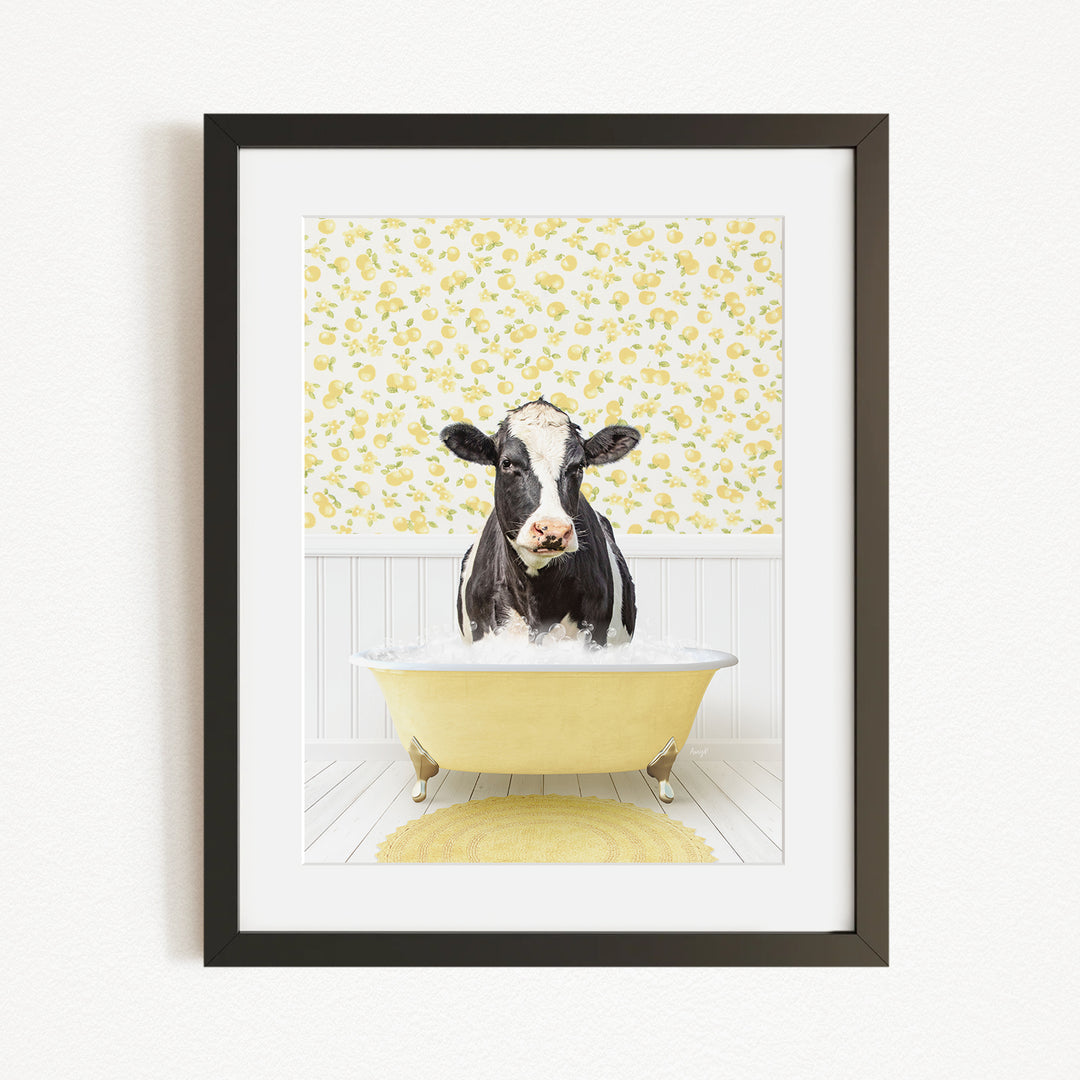 A black and white cow is sitting in a yellow bathtub filled with bubbles, surrounded by a yellow floral wallpaper.
