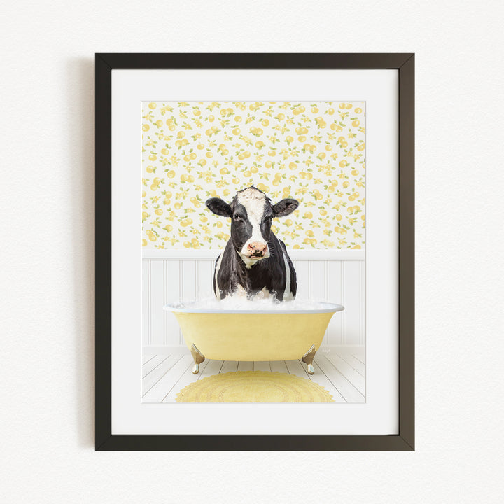 A black and white cow is sitting in a yellow bathtub filled with bubbles, surrounded by a yellow floral wallpaper.