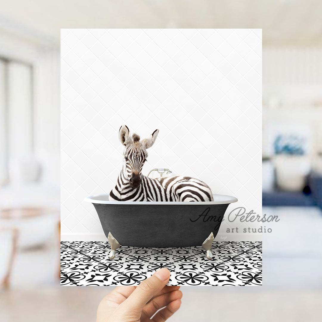 a hand holding a card with a zebra in a bathtub