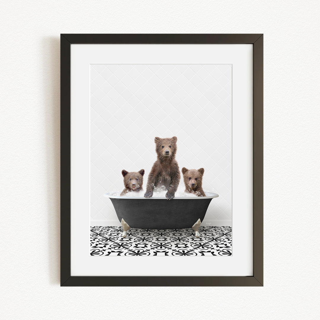A framed image depicting three bears sitting in a bathtub, with one bear standing and the other two sitting.