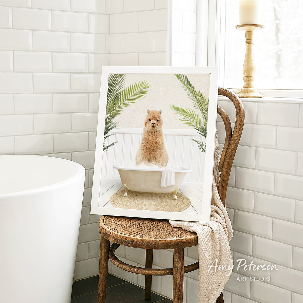 A framed image of a brown dog sitting in a bathtub, surrounded by green plants, is displayed on a wooden chair in a bathroom setting.