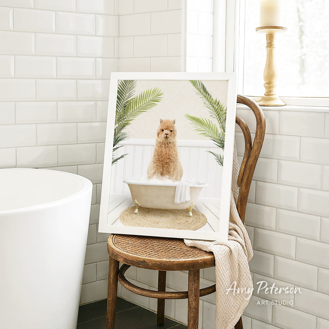 A framed image of a brown dog sitting in a bathtub, surrounded by green plants, is displayed on a wooden chair in a bathroom setting.