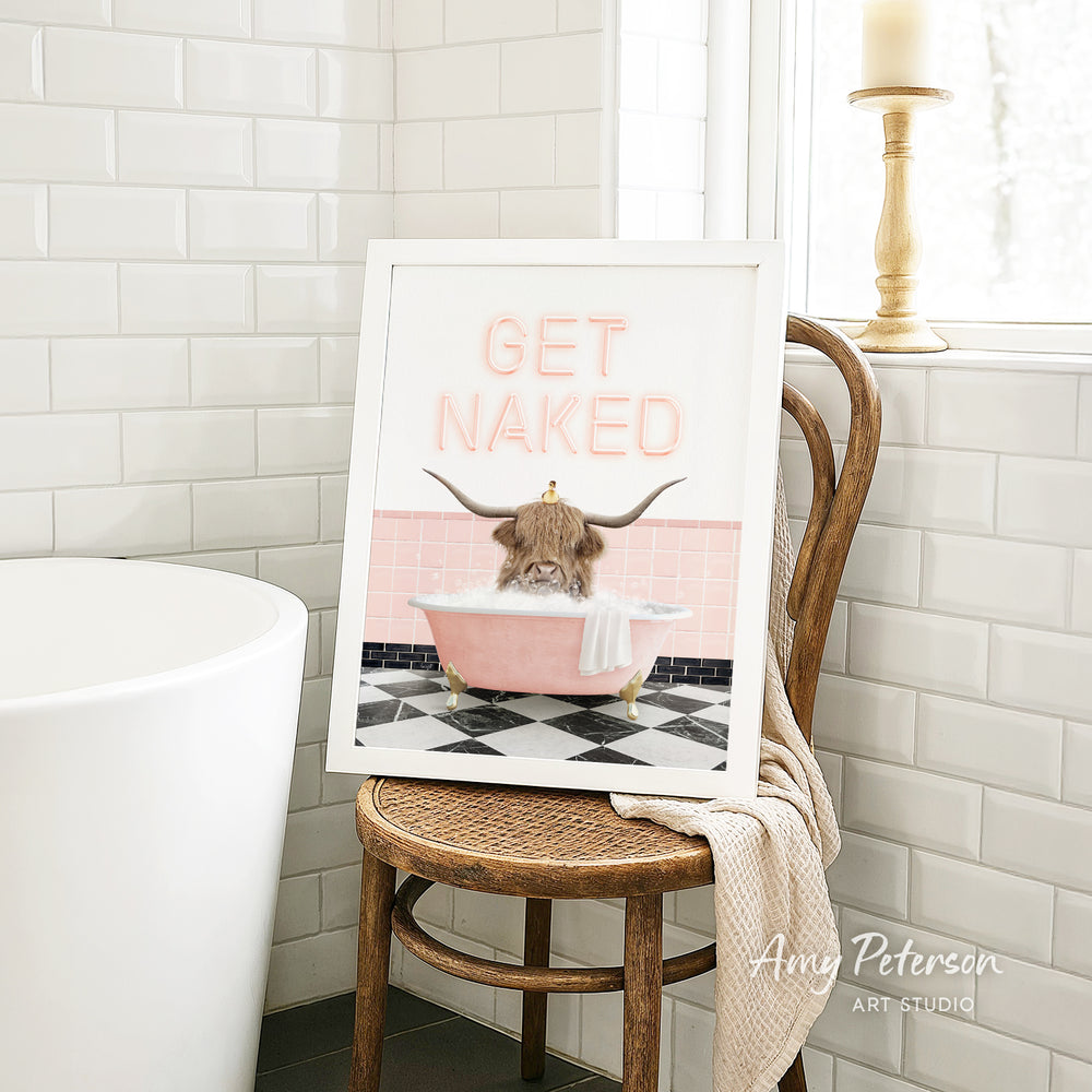 A framed image of a cat sitting in a pink bathtub, with the text "GET NAKED" displayed on the frame.