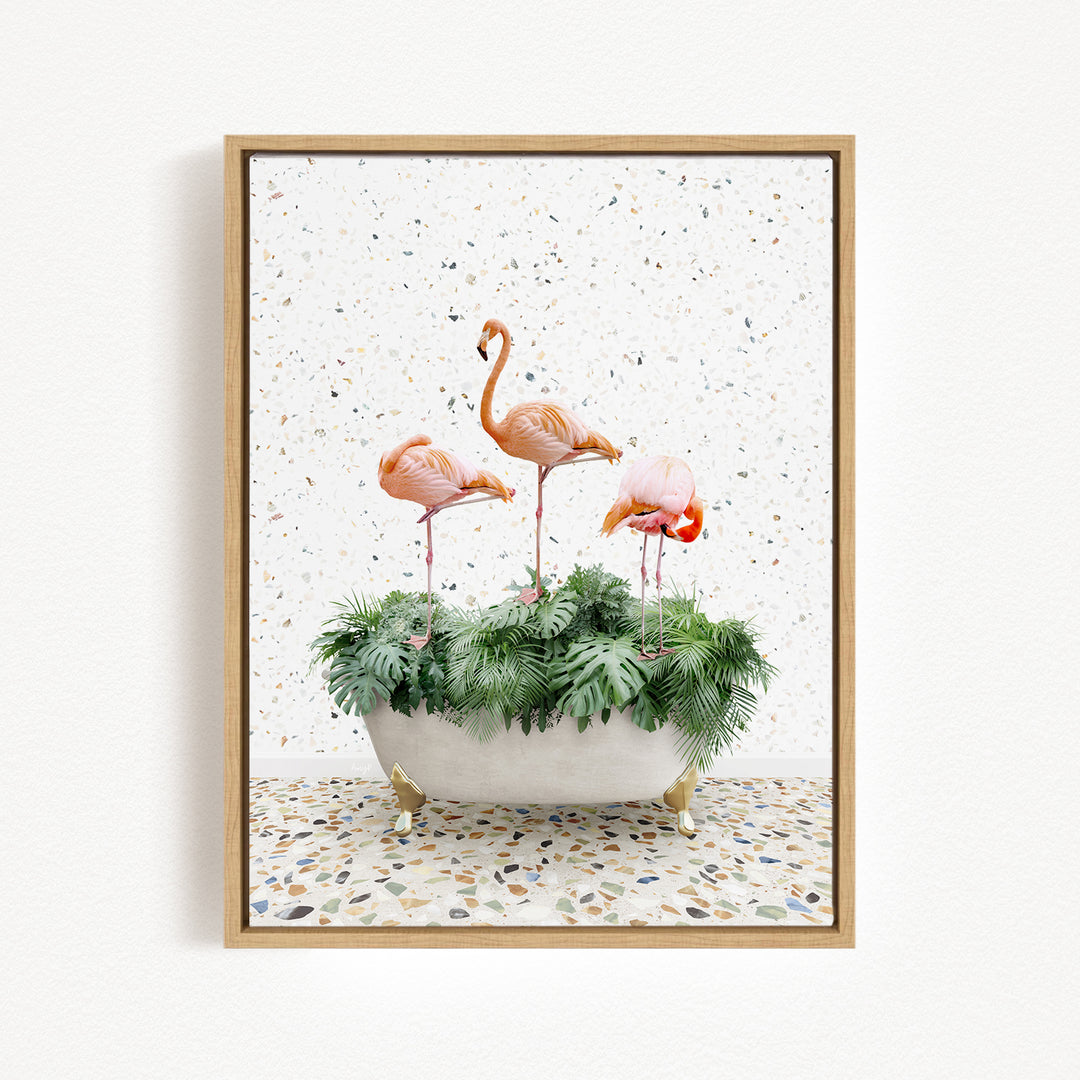A framed image depicting three pink flamingos standing in a white bathtub filled with green plants, set against a speckled white background.