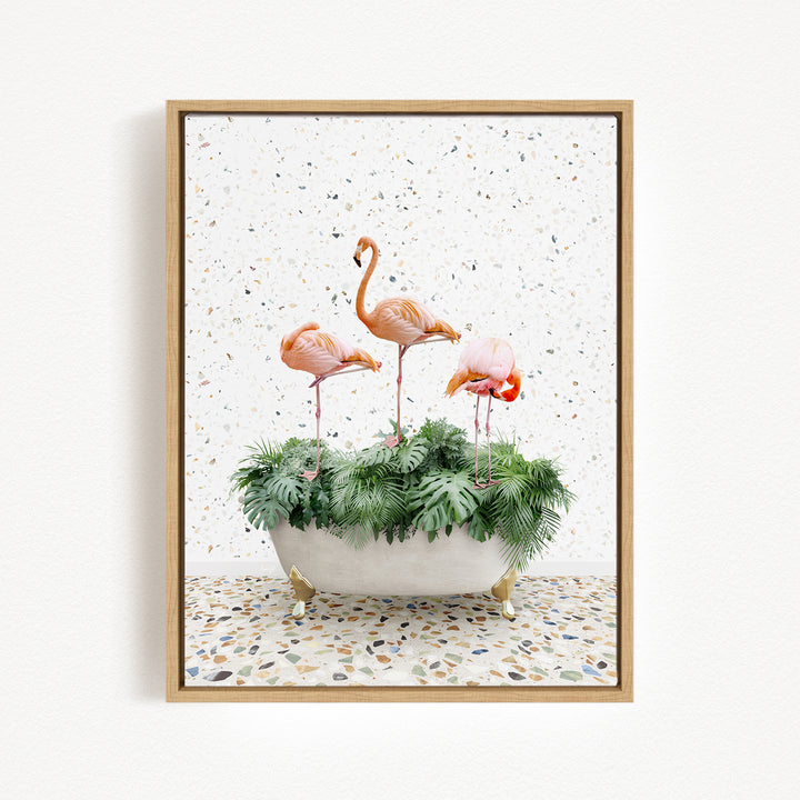 A framed image depicting three pink flamingos standing in a white bathtub filled with green plants, set against a speckled white background.