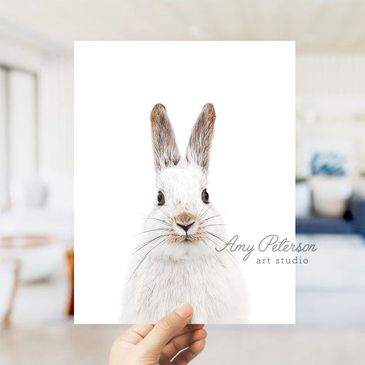 a person holding up a card with a picture of a rabbit