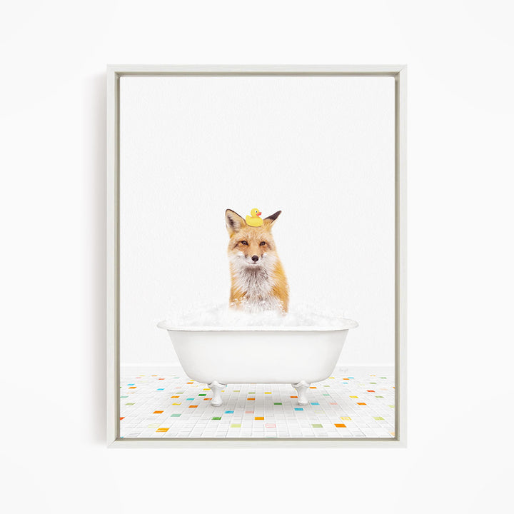 A fox is sitting in a white bathtub filled with bubbles, surrounded by a few rubber ducks.