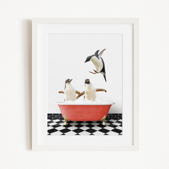 A framed image depicting two penguins sitting in a red bathtub, with one penguin flying towards the other in mid-air.