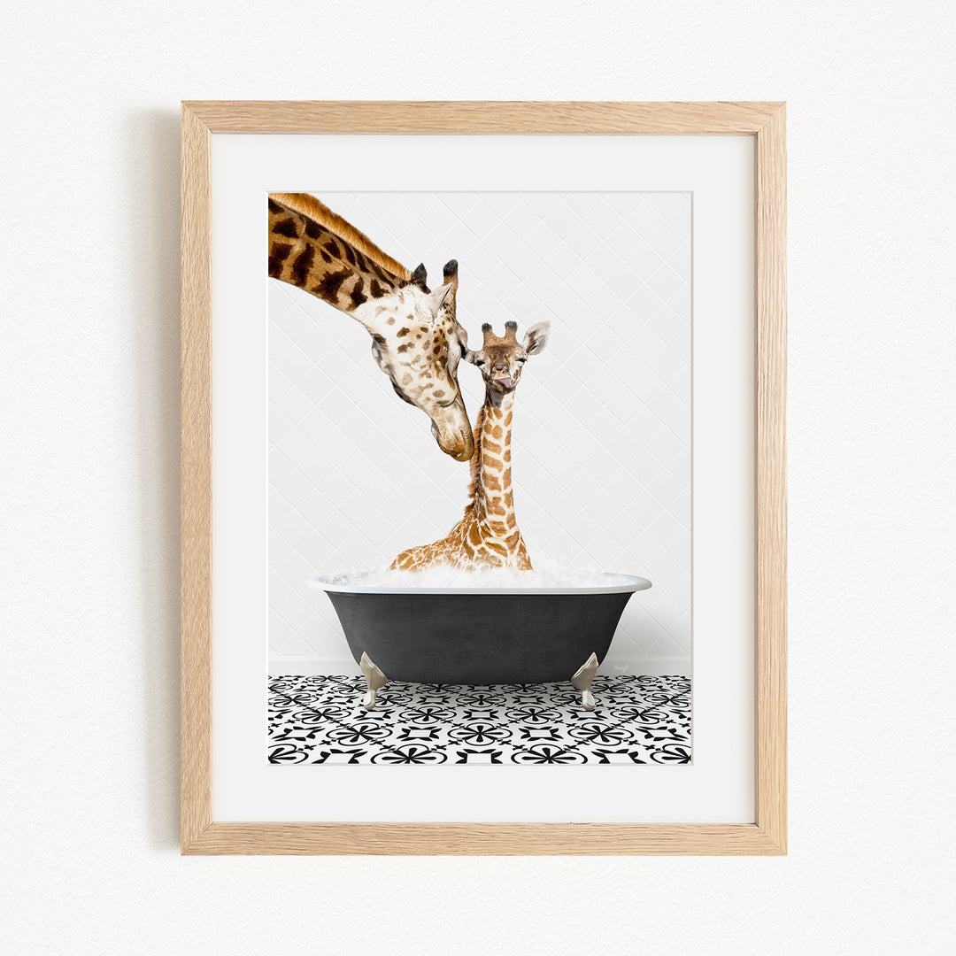 A mother giraffe and her baby giraffe are sitting together in a black bathtub, with the mother gently nuzzling her baby.