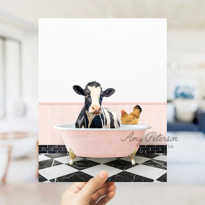 a person holding up a card with a picture of a cow in a bathtub