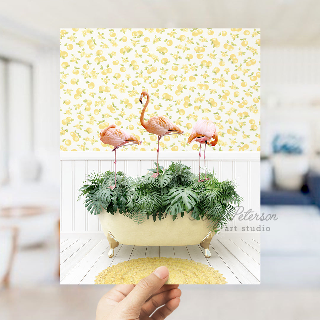 a person holding up a card with flamingos in a bathtub