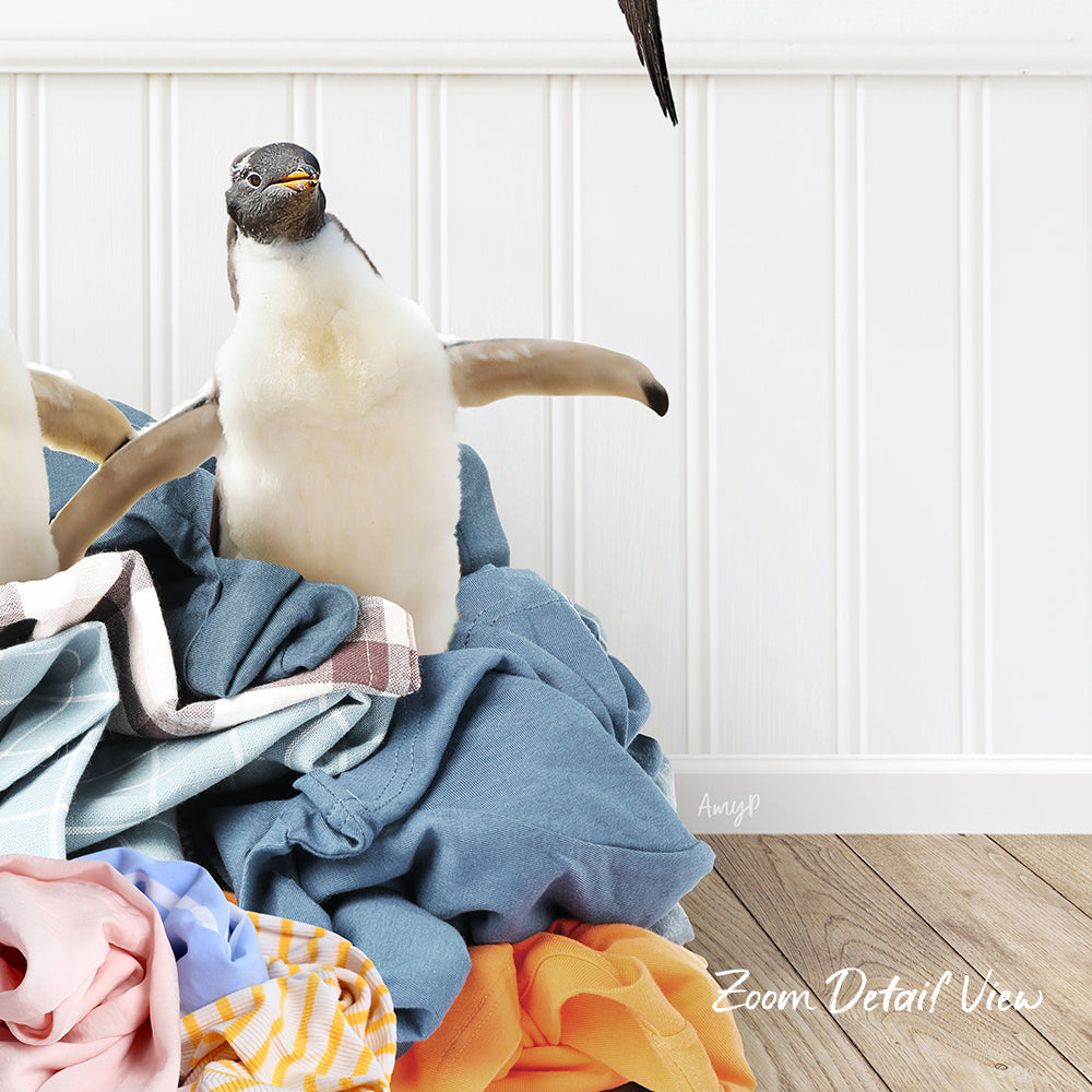 A penguin standing on a pile of clothes, with a white wall and wooden floor in the background.