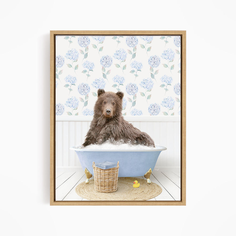 A brown bear sitting in a blue bathtub filled with bubbles, surrounded by a wicker basket and rubber ducks.