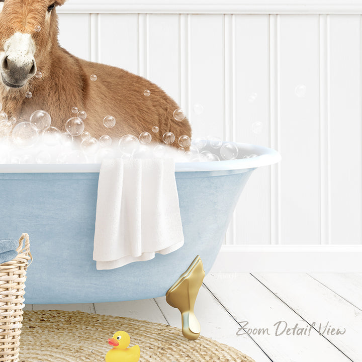 A donkey is sitting in a blue bathtub filled with bubbles, surrounded by a yellow rubber duck and a white towel.