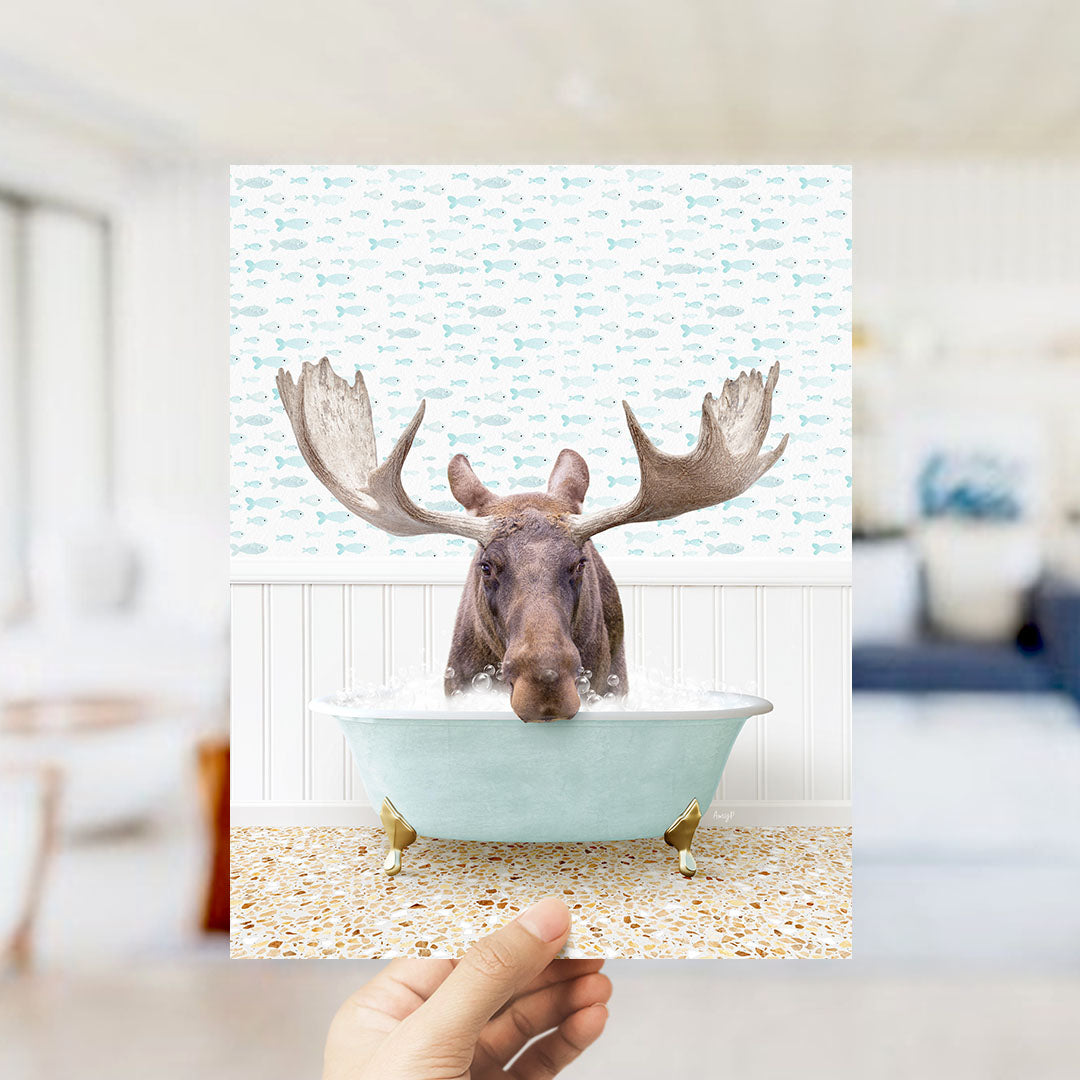 A moose with large antlers is sitting in a bathtub filled with water, surrounded by a pattern of fish.
