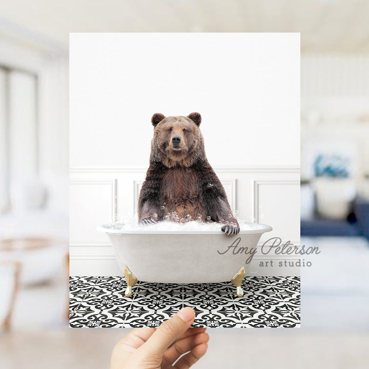 a person holding up a card with a bear in a bathtub