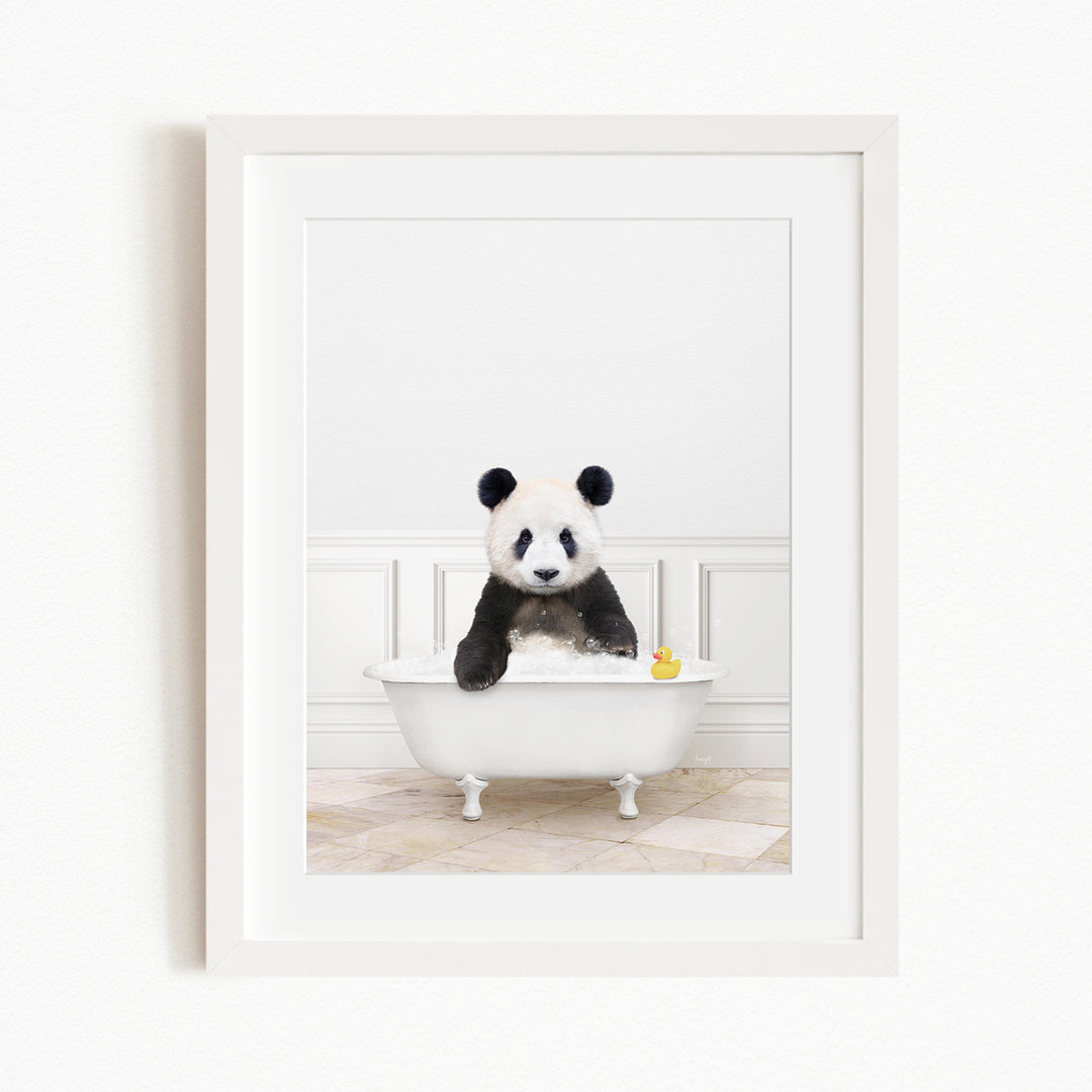 A panda bear sitting in a white bathtub, surrounded by a yellow rubber duck.