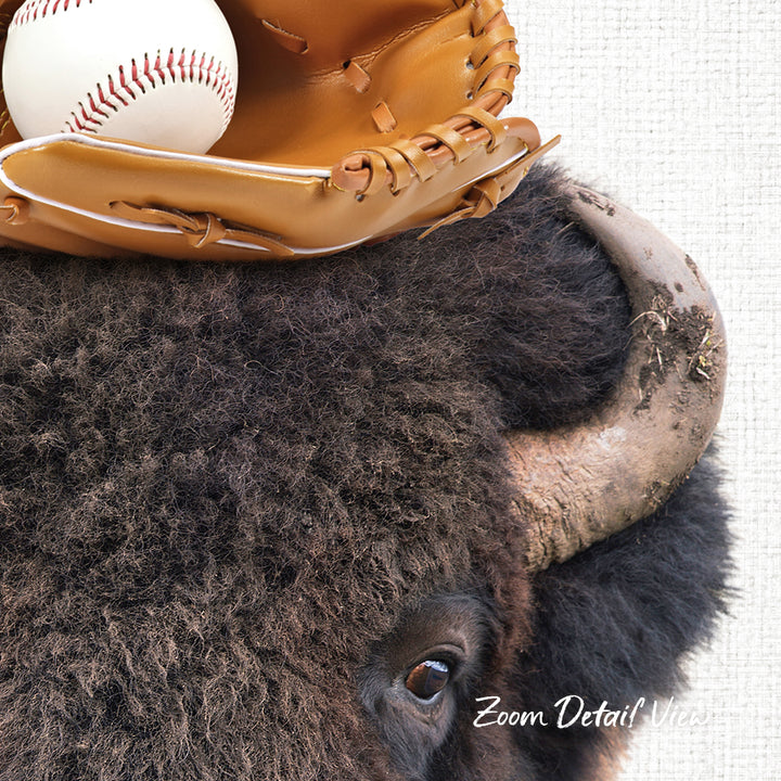 A close-up of a bison's head, with a baseball glove resting on top of it.
