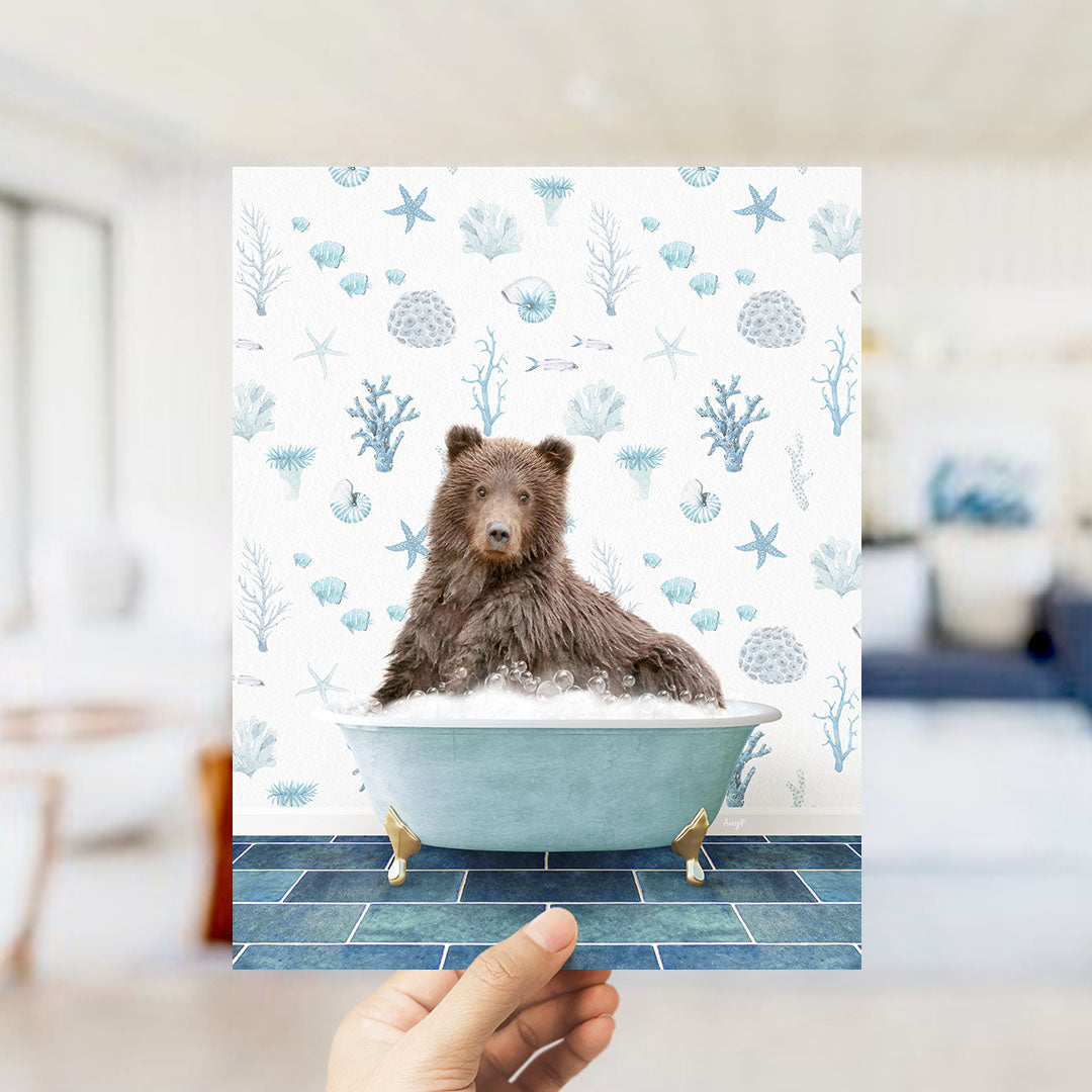 A brown bear sitting in a blue bathtub filled with bubbles, surrounded by a pattern of seashells, starfish, and other marine life.