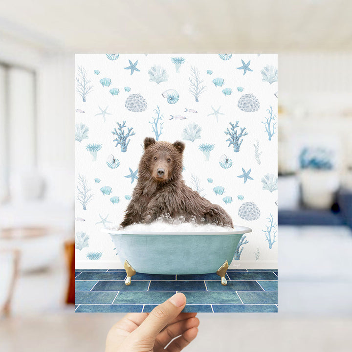 A brown bear sitting in a blue bathtub filled with bubbles, surrounded by a pattern of seashells, starfish, and other marine life.