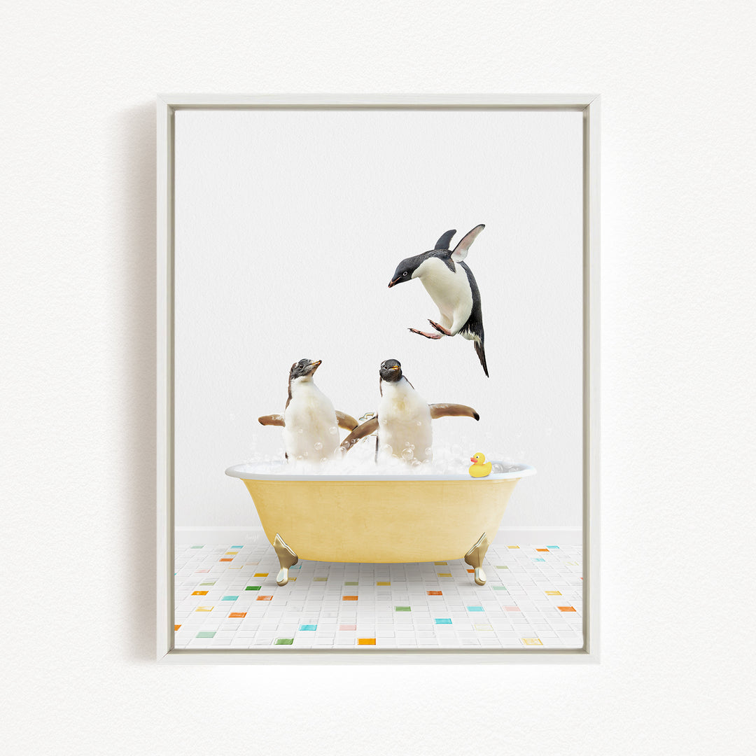 A framed image depicting two penguins sitting in a yellow bathtub, with one penguin jumping out of the tub and another penguin sitting in the tub.