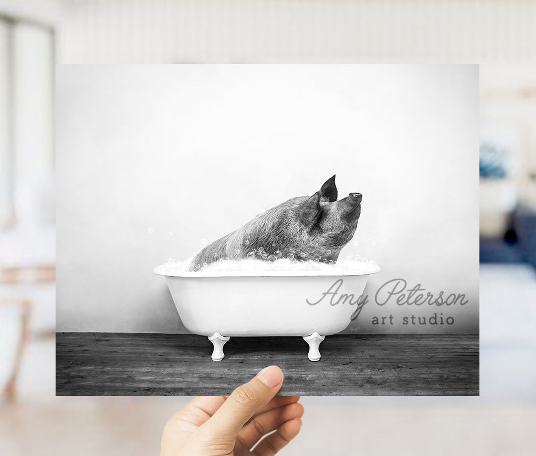 a hand holding up a black and white photo of a dog in a bathtub