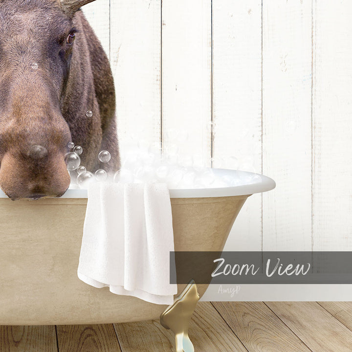 A close-up of a moose's head in a bathtub filled with bubbles, with a towel and wooden paneling in the background.