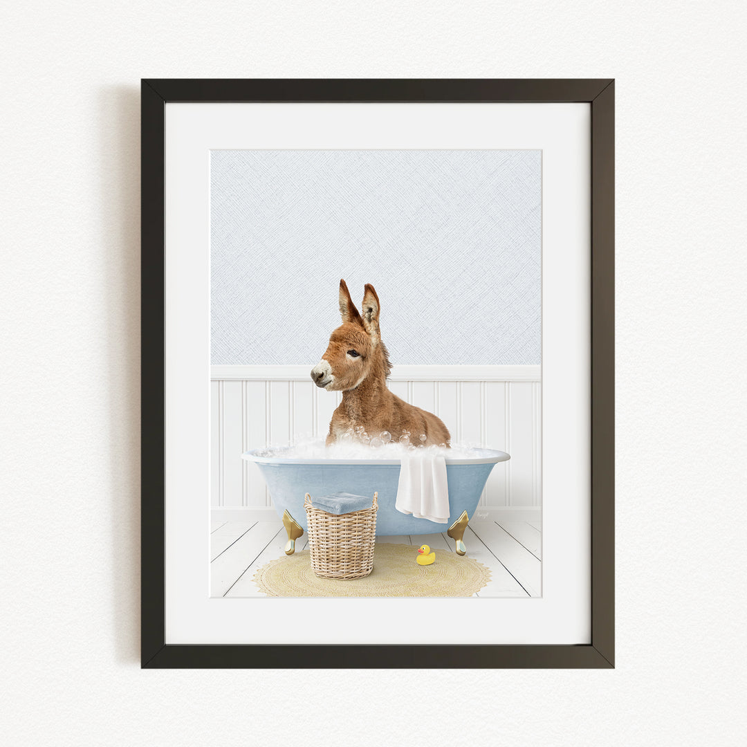 A donkey is sitting in a bathtub filled with water, surrounded by rubber ducks.