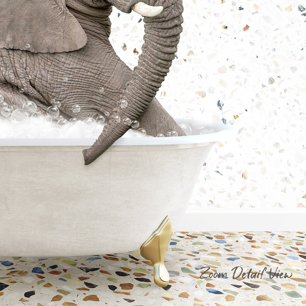 A large elephant is sitting in a bathtub filled with bubbles, with its trunk submerged in the water.