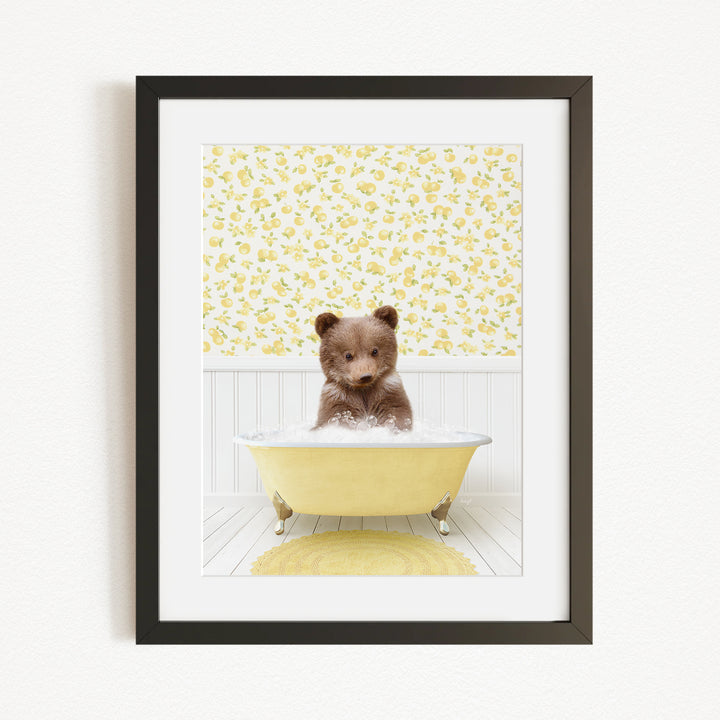 A small brown bear sitting in a yellow bathtub filled with water, surrounded by a yellow floral wallpaper.
