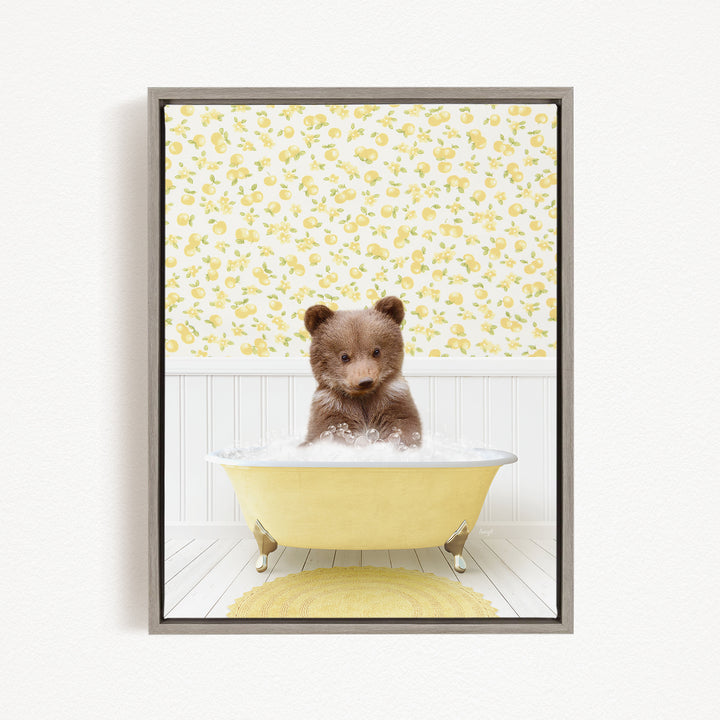 A cute brown bear sitting in a yellow bathtub filled with water, surrounded by a yellow floral wallpaper.