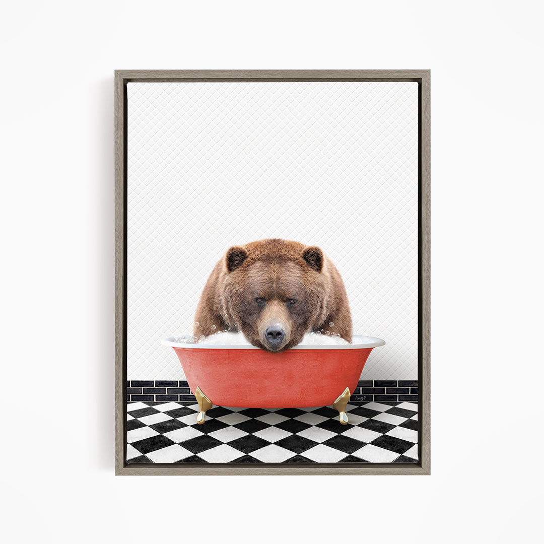 A brown bear is sitting in a red bathtub, appearing to be enjoying a bath.