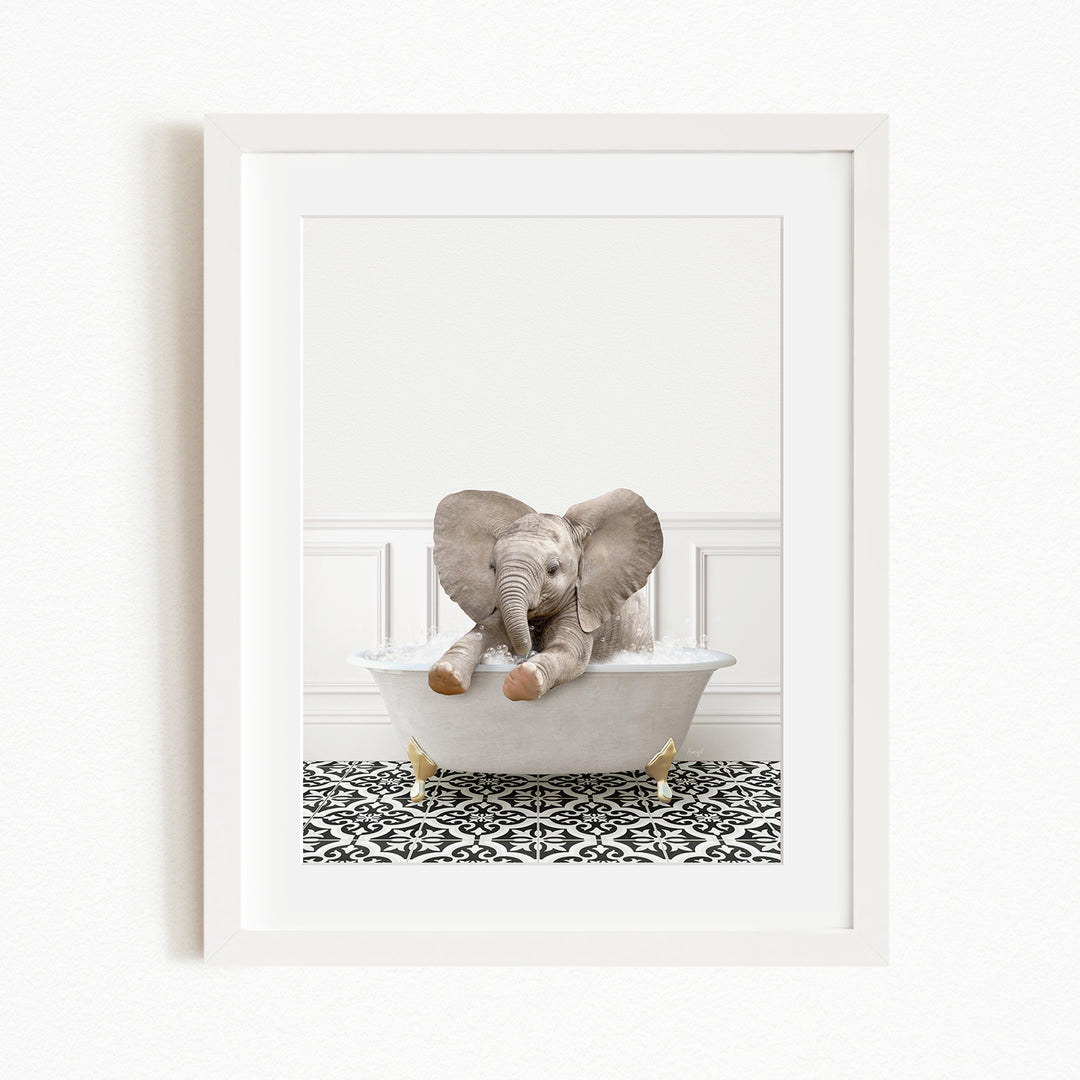 A baby elephant sitting in a white bathtub, with its trunk curled up and its ears spread out, against a white wall and black and white patterned floor.