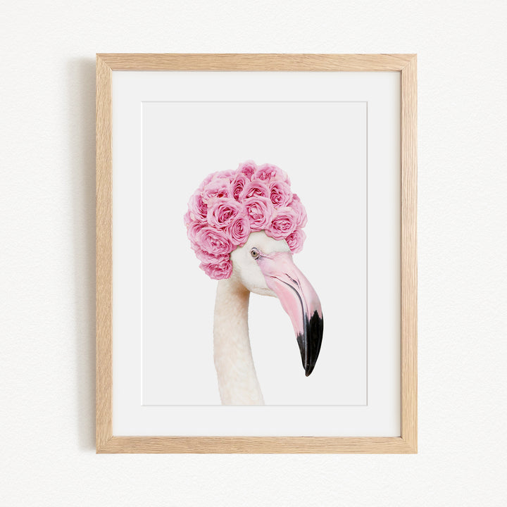 A framed image of a flamingo with a pink flower crown on its head.