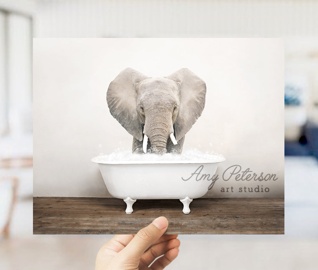 a person holding up a card with an elephant in a bathtub