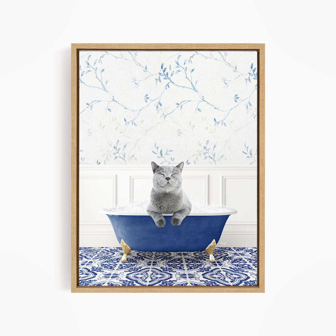 A gray cat sitting in a blue bathtub, with a patterned tile floor and a floral wallpaper in the background.