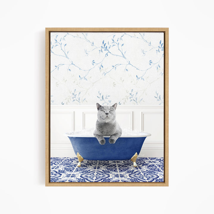 A gray cat sitting in a blue bathtub, with a patterned tile floor and a floral wallpaper in the background.
