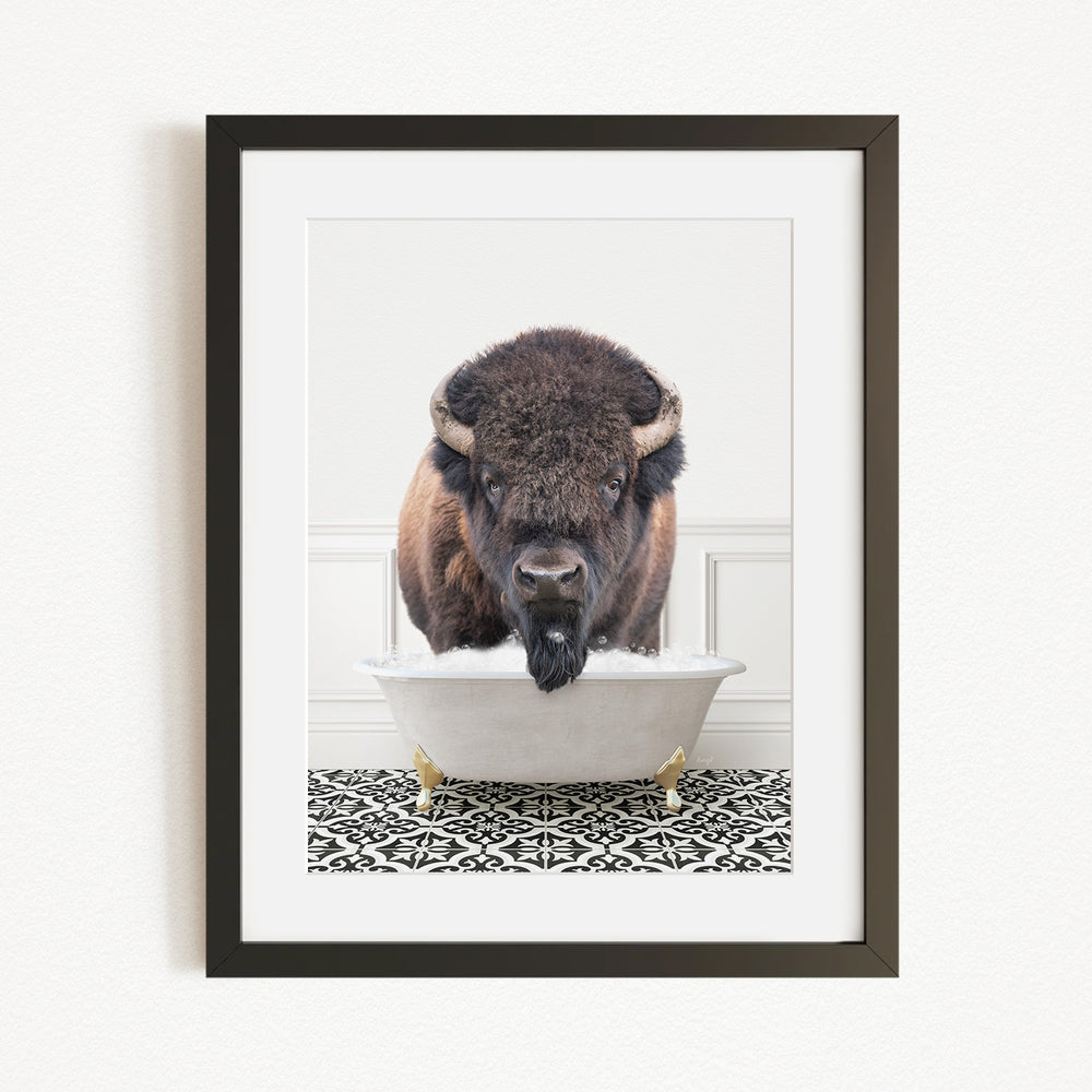 A buffalo with a black mane and horns is standing in a white bathtub filled with water, creating a whimsical and humorous scene.