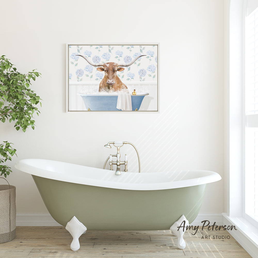 a green clawfoot bathtub with a framed picture of a cow sitting in it on the wall above it.