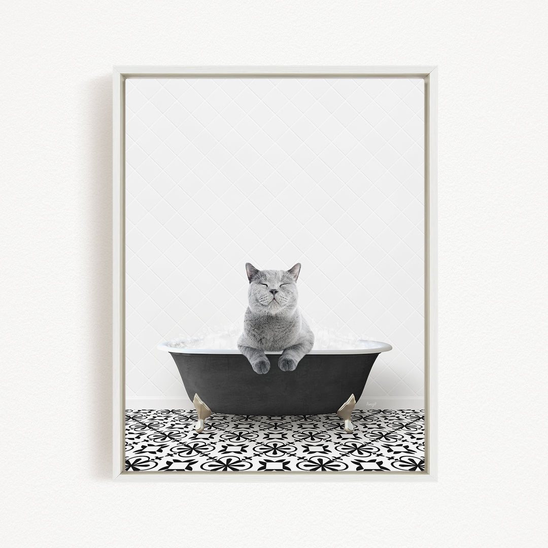 A gray cat sitting in a black bathtub filled with bubbles, with a black and white patterned floor in the background.