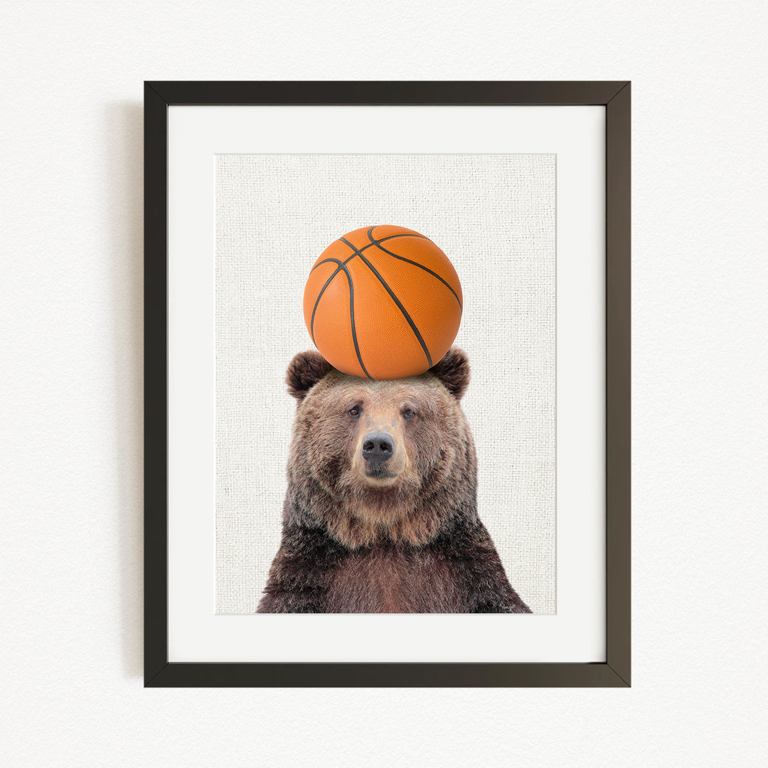 A brown bear balancing a basketball on its head.