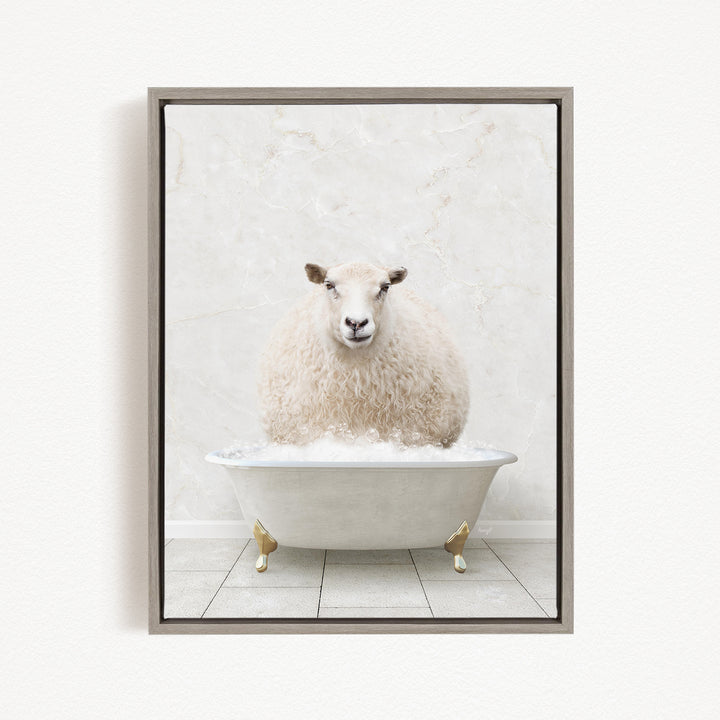 A fluffy white sheep sits in a white bathtub filled with bubbles, looking directly at the camera.