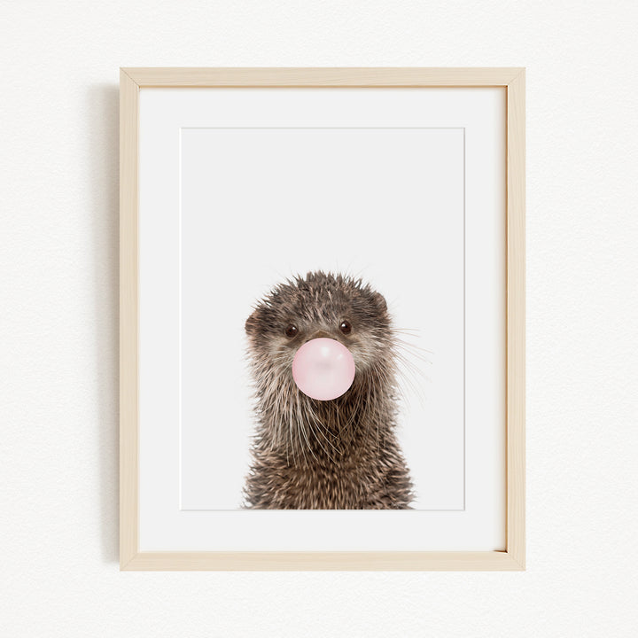 A picture of an otter blowing a bubble with a pink bubble gum bubble.