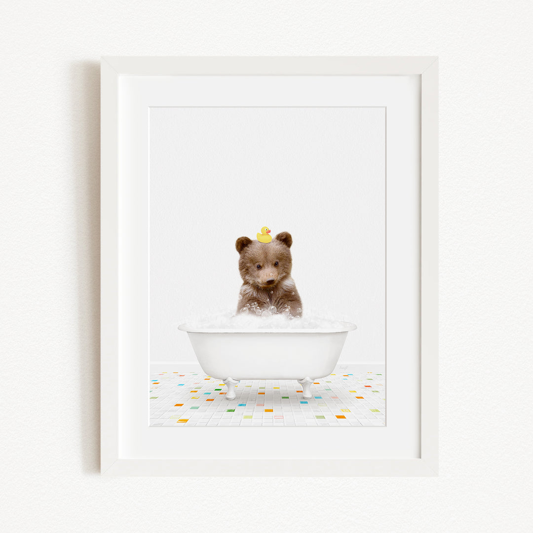 A brown bear sitting in a white bathtub filled with bubbles, with a yellow rubber duck on its head.