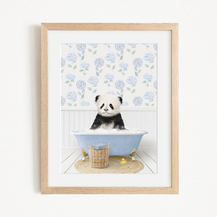 A cute panda bear sitting in a blue bathtub, surrounded by a floral patterned wall and a basket of rubber ducks.