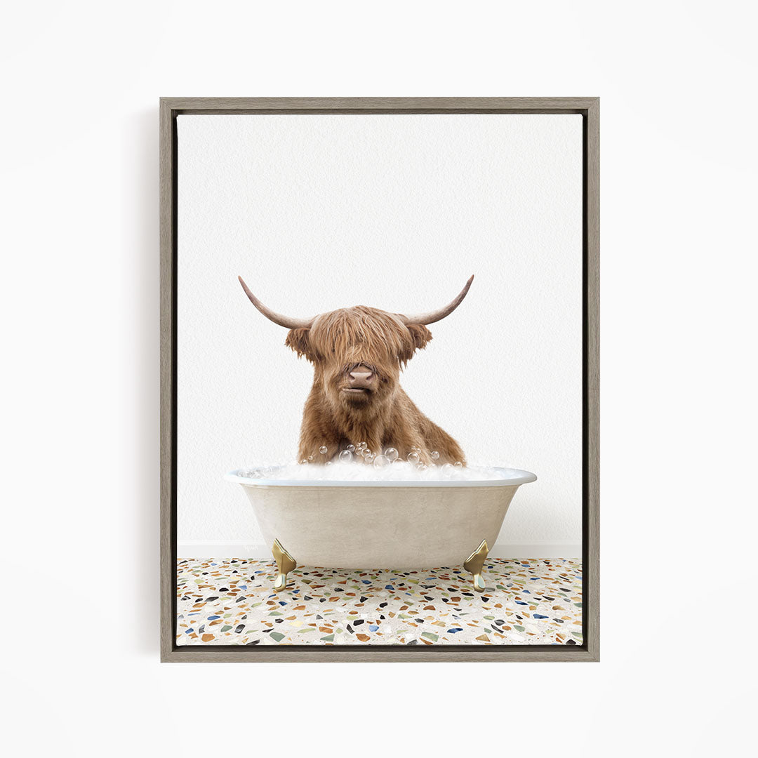 A Highland cow with long horns is sitting in a white bathtub filled with water, creating a whimsical and amusing scene.